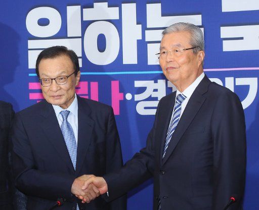 Ruling, opposition leaders Lee Hae-chan (L), leader of the ruling Democratic Party, and Kim Chong-in, interim leader of the main opposition United Future Party, shake hands during the latter\