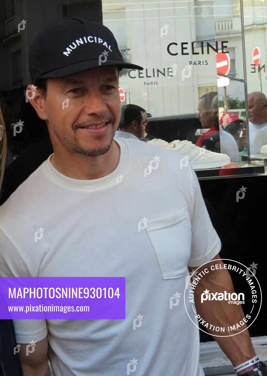 Mark Wahlberg seen giving a shoes box to a young boy as he leaves the Bon Marché in Paris