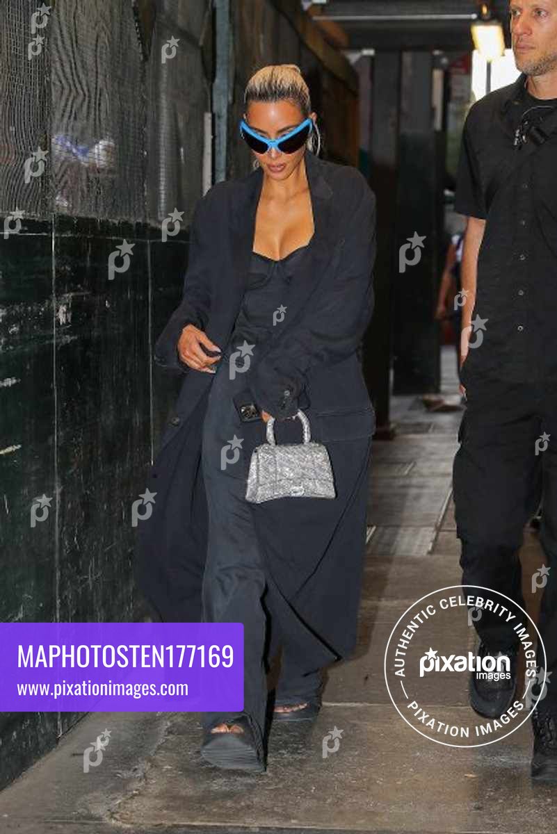 Kim Kardashian throws a peace sign as checking out her hotel in New York City